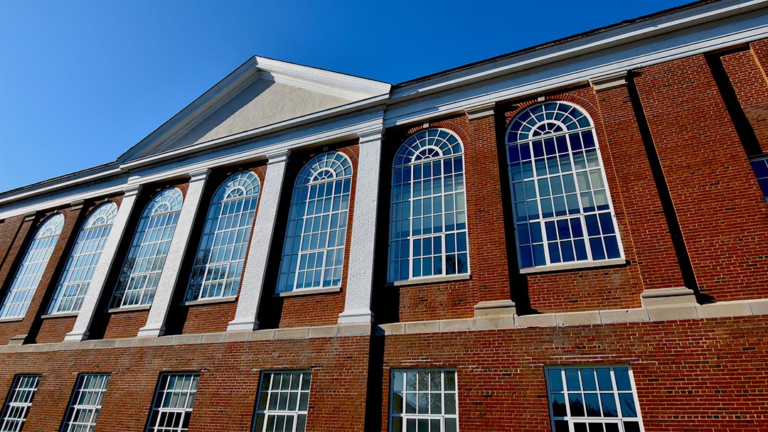 SMCM Kent Hall architectural detail photo of brick facade and window on a blue sky sunny day