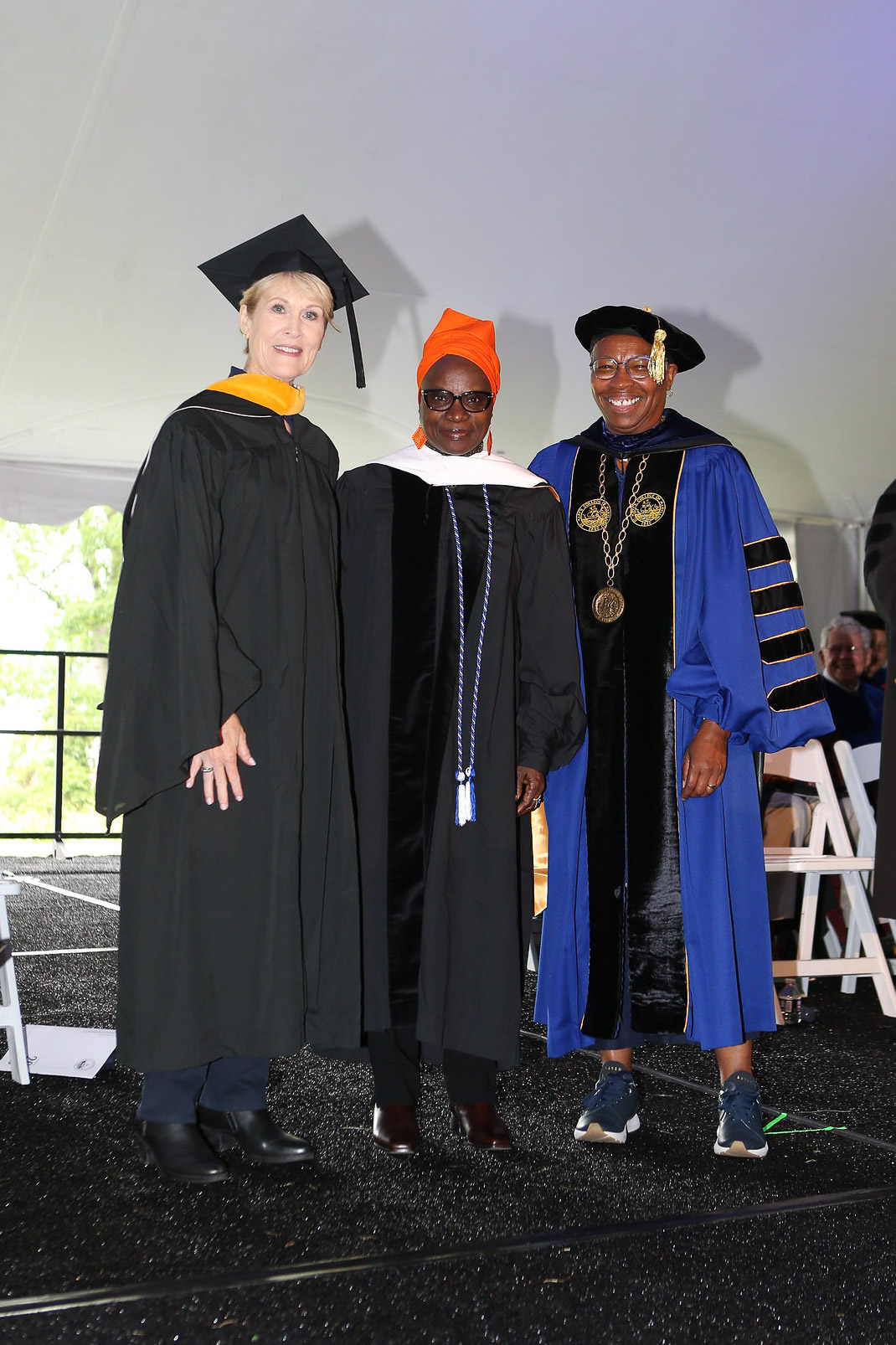 From left, Board Chair Susan Dyer, Angélique Kidjo, and President Tuajuanda C. Jordan pose on stage during Commencement