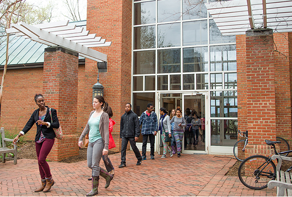 Multiple people walking out of the entrance to the Hilda C. Landers library