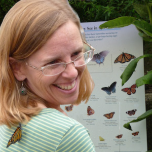 Laura M. Ahearn in front of butterfly pictures
