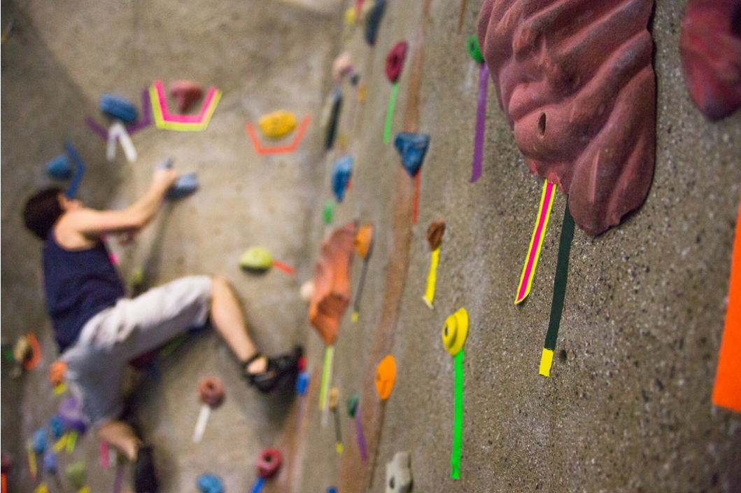 a smcm student climbing on the rock wall in the arc