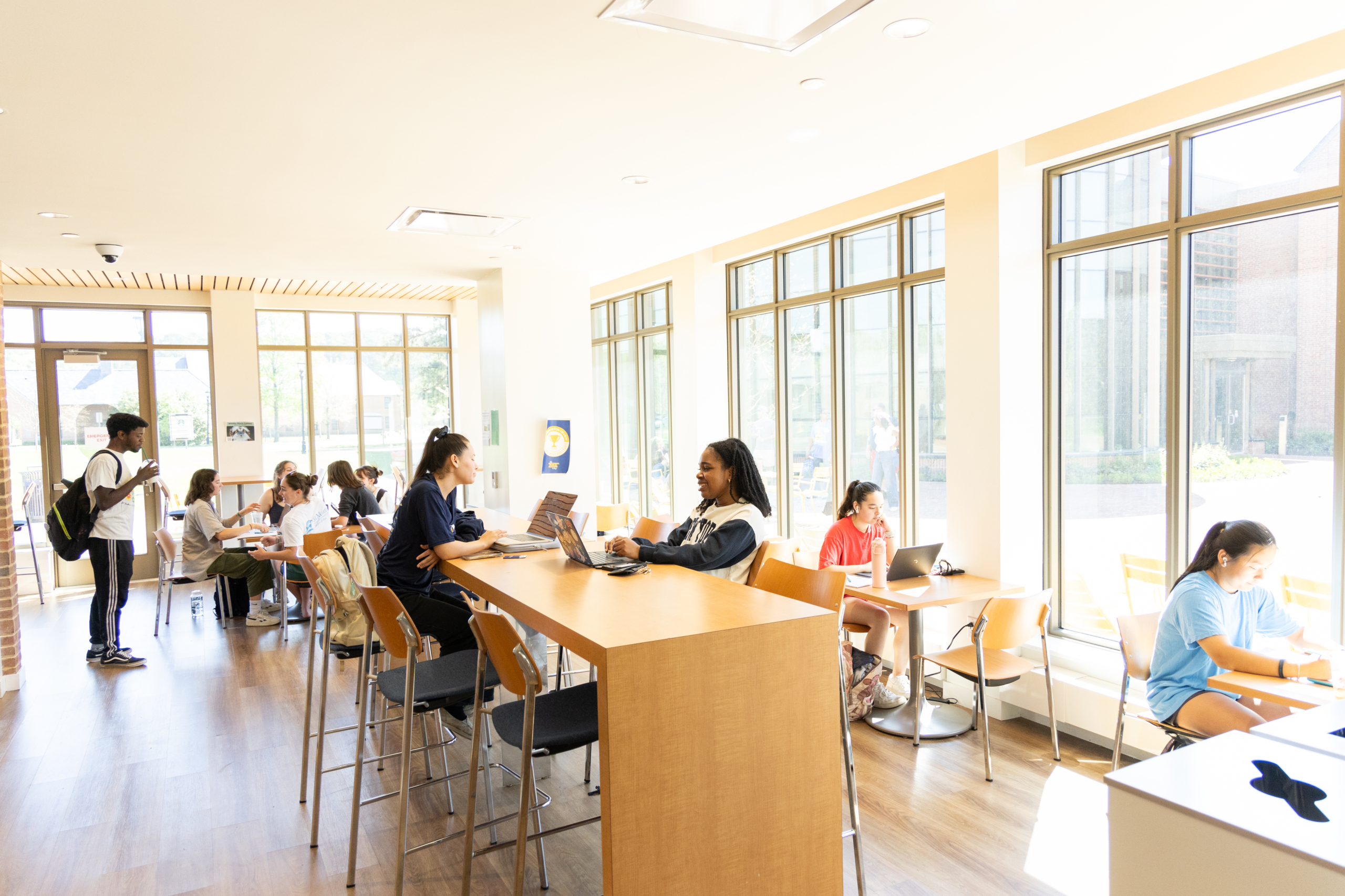 A nice study place where students are having conversations and studying and doing homework.