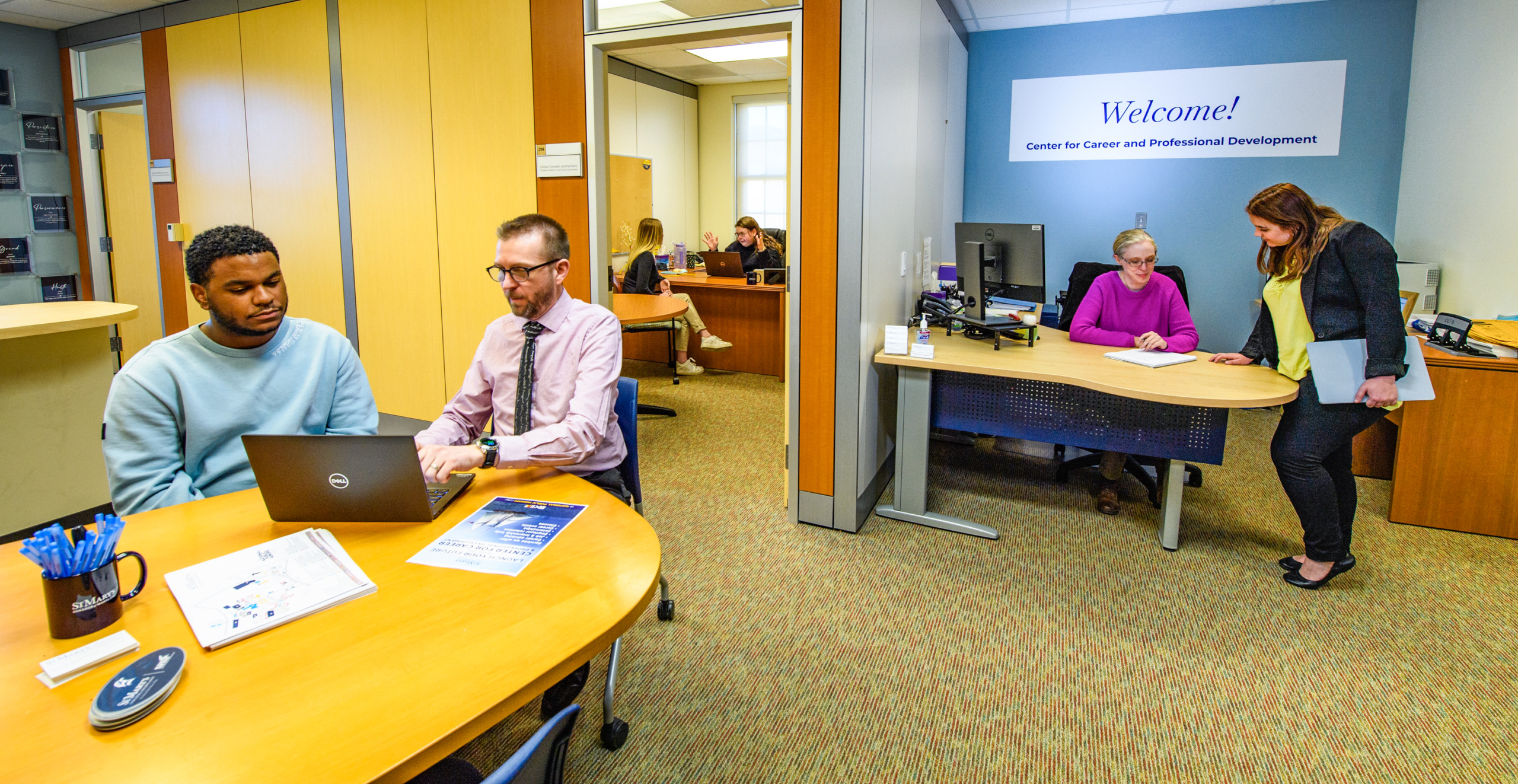 Photo of students getting help from College staff in the Center for Career & Professional Development