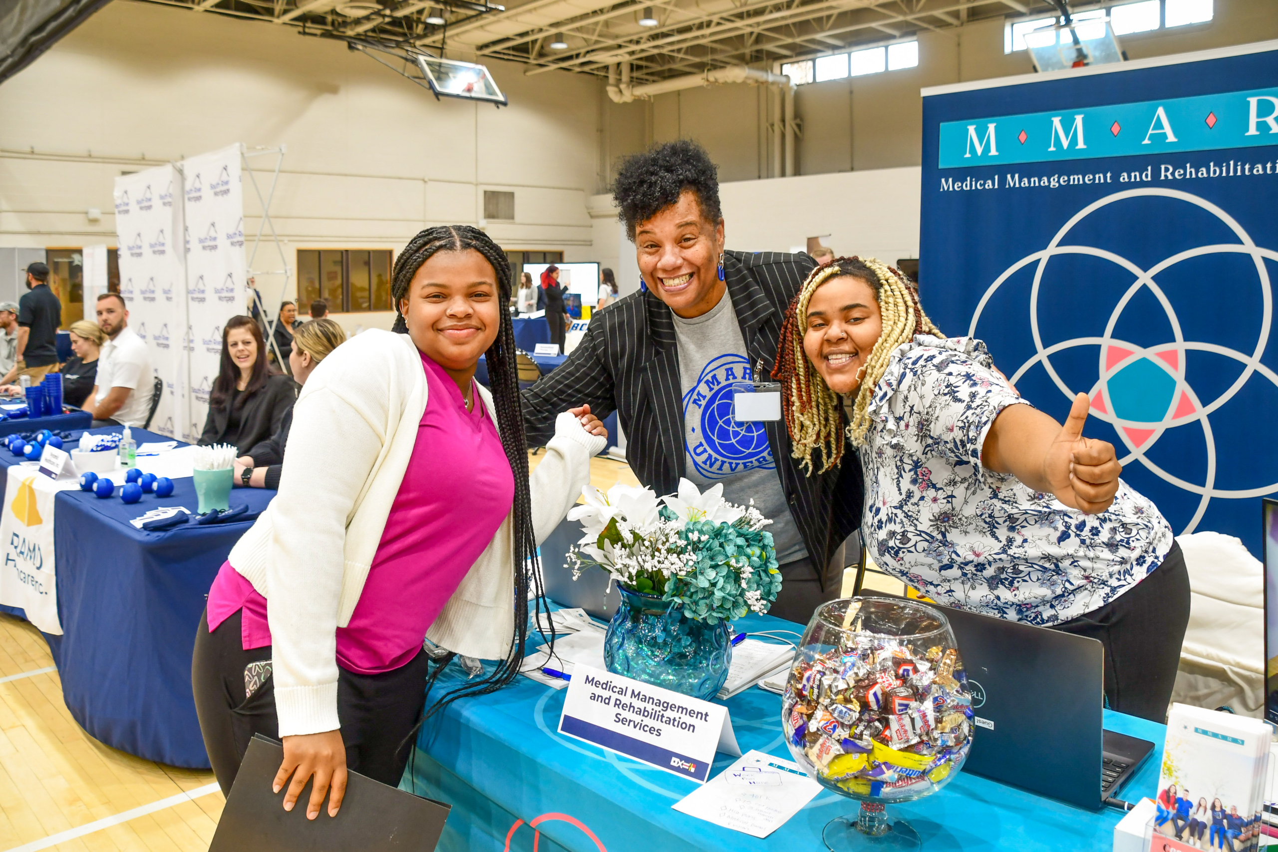 Photo of a student celebrating with two employer representatives at St. Mary's College of Maryland's Career & Internship Fair