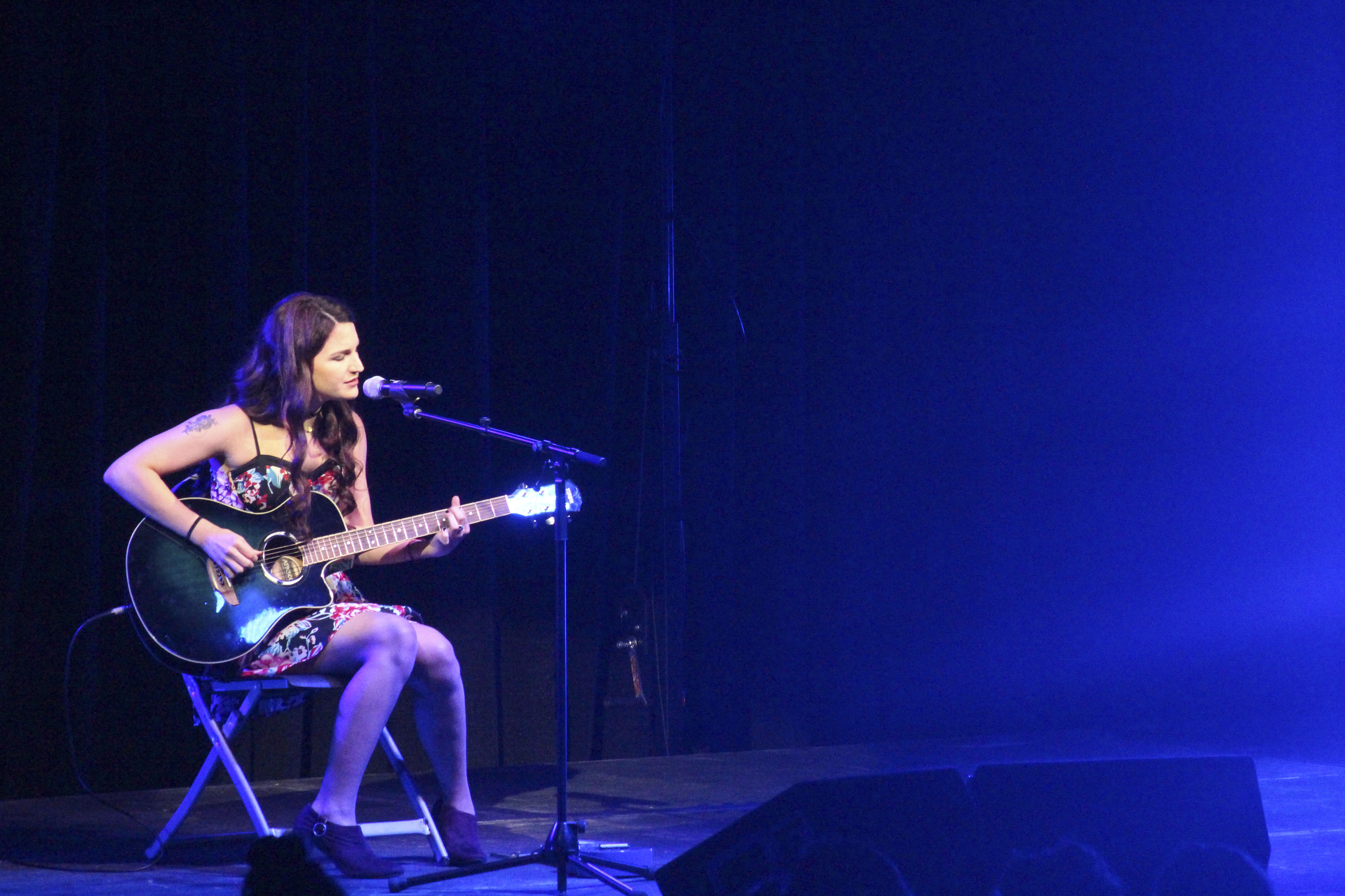 A student playing guitar on stage