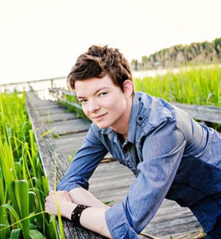 Griffyn Gilligan poses on a bridge over a marsh.