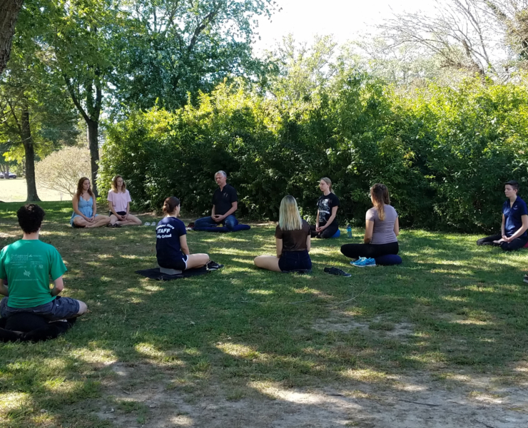 Students meditating outside