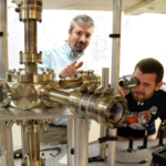Student and professor examine vacuum chamber