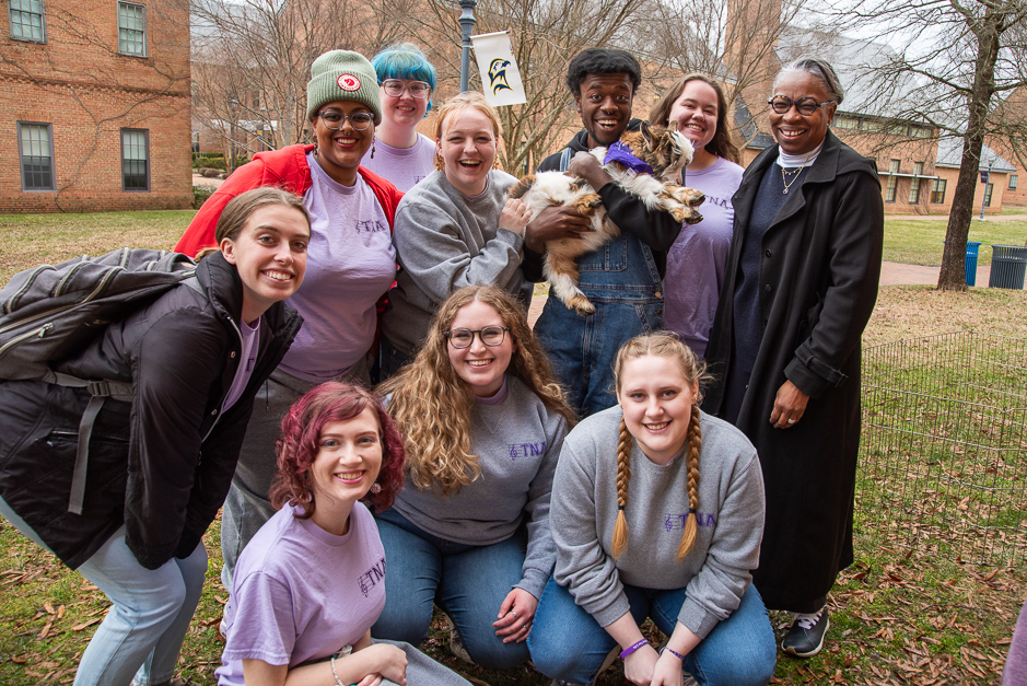 President Jordan and a group of students pose with a young goat outside of the ARC