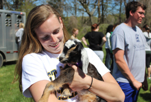 St. Mary's student holds a goat on campus
