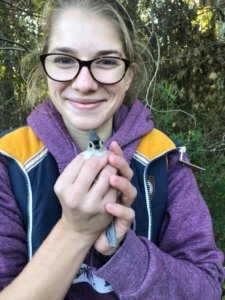Livia Schuller holds a white-throated sparrow