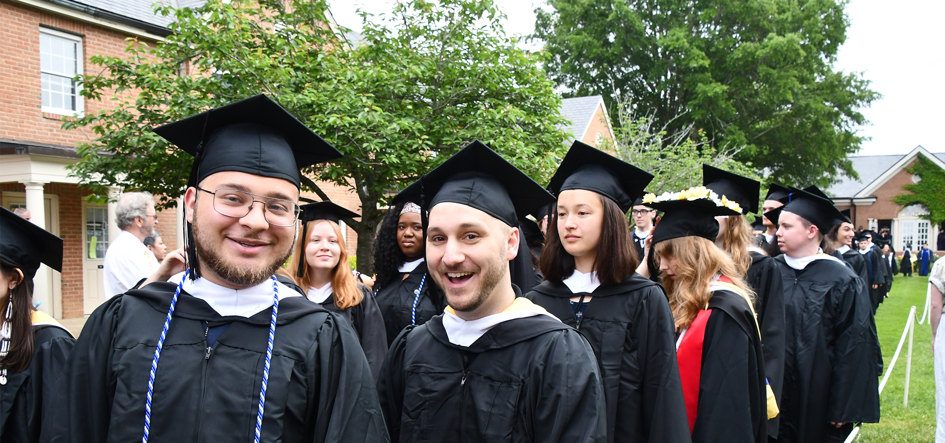 Image of students dressed in graduation attire in a line